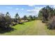 Exterior view of the property with a lush green lawn under a sunny sky with scattered clouds at 8122 Pine Island Rd, Clermont, FL 34711