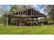 Open-air garage with tractor, lawnmowers and storage shelves at 8122 Pine Island Rd, Clermont, FL 34711