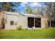 A well-maintained metal garage with an open entrance, surrounded by a neatly mowed lawn and trees at 8122 Pine Island Rd, Clermont, FL 34711