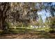 Picturesque landscape featuring mature trees, open land, and the home site on a bright, sunny day at 8122 Pine Island Rd, Clermont, FL 34711