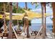 Lakeside dining area with picnic tables shaded by sails, offering a breezy and scenic spot to savor outdoor meals at 8122 Pine Island Rd, Clermont, FL 34711