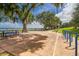 Scenic park view features shady trees, park benches, and paved walking paths along the waterfront at 8122 Pine Island Rd, Clermont, FL 34711