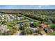 Extensive aerial view of homes and pond surrounded by a landscape of both residential properties and natural woodland at 8155 Brocatel Ct, Orlando, FL 32822