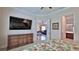 Spacious bedroom opens to living room and bath, with TV on wall at 842 Aldenham Ln, Ormond Beach, FL 32174