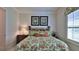 Bedroom featuring floral bedding, tropical wall decor, and natural light at 842 Aldenham Ln, Ormond Beach, FL 32174