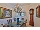 Formal dining room featuring a glass-top table with seating for four and a decorative chandelier for elegant dinners at 842 Aldenham Ln, Ormond Beach, FL 32174