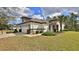 Inviting home featuring a lush green lawn, trimmed bushes, and a stone accent wall at 842 Aldenham Ln, Ormond Beach, FL 32174