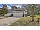 Charming home featuring a brick driveway, two-car garage, manicured lawn, and an American flag displayed on the front at 842 Aldenham Ln, Ormond Beach, FL 32174