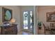 Inviting foyer featuring a tiled floor, elegant furnishings, and a front door with glass panels and sidelights at 842 Aldenham Ln, Ormond Beach, FL 32174