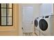 Modern laundry room with front-load washer and dryer and overhead cabinets at 842 Aldenham Ln, Ormond Beach, FL 32174