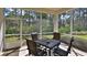 Screened-in patio with dining set and wooded view offers tranquil outdoor living at 842 Aldenham Ln, Ormond Beach, FL 32174