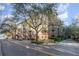 Beautiful condominium building featuring multiple balconies, manicured landscaping, and tree-lined street at 911 N Orange Ave # 110, Orlando, FL 32801