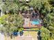 An aerial view of a property with a screened-in pool, patio, and lush backyard at 916 Puma Trl, Winter Springs, FL 32708