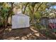 Backyard shed behind a chain link fence, surrounded by mature landscaping and trees at 916 Puma Trl, Winter Springs, FL 32708