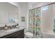 Bright bathroom features a vanity, toilet, and shower with a patterned curtain for a pop of color and charm at 10139 Grande Loop, Clermont, FL 34711