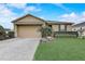 Charming single-story home with a well-manicured lawn, beautiful landscaping, and a two-car garage at 10139 Grande Loop, Clermont, FL 34711
