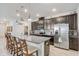 Modern kitchen featuring a granite island, stainless steel appliances, and elegant dark wood cabinetry at 10139 Grande Loop, Clermont, FL 34711