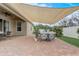 Spacious patio featuring brick pavers, outdoor furniture, a shade sail, and string lights for a cozy atmosphere at 10139 Grande Loop, Clermont, FL 34711