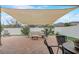 Inviting outdoor patio area with brick flooring, comfortable seating, and a shade sail, perfect for relaxing and entertaining at 10139 Grande Loop, Clermont, FL 34711