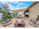 Relaxing patio with a fire pit, comfortable rocking chairs, and a stylish shade sail, great for enjoying outdoor living at 10139 Grande Loop, Clermont, FL 34711