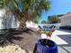 Landscaped backyard with stone pavers leading to outdoor seating, privacy landscaping, and a large palm tree at 113 Avalon Dr, Ormond Beach, FL 32176