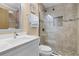Modern bathroom with a glass-enclosed shower, white vanity, and stone tile flooring at 113 Avalon Dr, Ormond Beach, FL 32176
