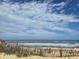 Scenic beach view with white sand, gentle waves, and beautiful blue sky with scattered clouds at 113 Avalon Dr, Ormond Beach, FL 32176