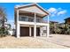 Two-story home featuring a balcony and a three-car garage underneath the living space at 113 Avalon Dr, Ormond Beach, FL 32176