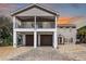 Two-story coastal home featuring a double garage, upper balcony, and manicured landscaping at 113 Avalon Dr, Ormond Beach, FL 32176