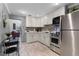 Open kitchen featuring white cabinets, stainless steel appliances, and tile backsplash at 113 Avalon Dr, Ormond Beach, FL 32176