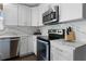 Bright kitchen features white cabinets, stainless steel appliances, and beautiful marble countertops at 113 Avalon Dr, Ormond Beach, FL 32176