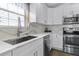 Modern kitchen featuring stainless steel appliances, white cabinets, quartz countertop, and hardwood floors at 113 Avalon Dr, Ormond Beach, FL 32176
