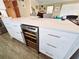 Kitchen island boasts white cabinets, quartz countertops, and a built-in wine refrigerator for added convenience at 113 Avalon Dr, Ormond Beach, FL 32176