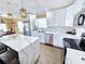 Bright kitchen with stainless steel appliances, white cabinets, a marble island, and modern light fixtures at 113 Avalon Dr, Ormond Beach, FL 32176