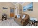 Cozy living room features a classic leather sofa, wood-look tile flooring, and tasteful nautical-themed decor at 113 Avalon Dr, Ormond Beach, FL 32176