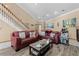 Inviting living room featuring hardwood floors, staircase, and comfortable leather furniture with nautical decor accents at 113 Avalon Dr, Ormond Beach, FL 32176