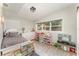 Bright bedroom featuring a large window, wood-look floors, a white bed and storage for toys at 1140 W Seminole Trl, Bartow, FL 33830