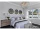 Bright bedroom with a chandelier, decorative wall art, bedside tables with lamps, and natural light from the window at 1593 Evening Summit Cir, Minneola, FL 34715