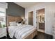 Stylish bedroom with a gray wall, wooden bed frame, closet, and a view into a bathroom at 1593 Evening Summit Cir, Minneola, FL 34715