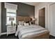 Cozy bedroom with a gray accent wall, a comfortable bed, and a view into the closet at 1593 Evening Summit Cir, Minneola, FL 34715