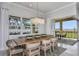 Bright dining room featuring a wooden table, stylish chairs, modern chandelier, and sliding glass doors at 1593 Evening Summit Cir, Minneola, FL 34715