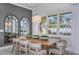 Bright dining room featuring a wooden table, stylish chairs, modern chandelier, and large windows at 1593 Evening Summit Cir, Minneola, FL 34715