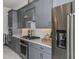 Modern kitchen with stainless steel appliances, gray cabinets, and white backsplash for a sleek and stylish design at 1593 Evening Summit Cir, Minneola, FL 34715