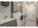 Functional laundry room with modern washer and dryer, sink and upper cabinets at 1593 Evening Summit Cir, Minneola, FL 34715