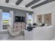 Comfortable living room with beamed ceiling, a large TV, stylish furniture, and expansive windows at 1593 Evening Summit Cir, Minneola, FL 34715