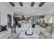 Open-concept living space with an island kitchen, dining area, and great room with beamed ceilings at 1593 Evening Summit Cir, Minneola, FL 34715