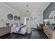Elegant main bedroom with dark hardwood floors, stylish furniture, large windows, and a decorative chandelier at 1593 Evening Summit Cir, Minneola, FL 34715