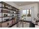 Well-appointed home office featuring custom shelving, modern décor, comfortable seating, and abundant natural light at 1593 Evening Summit Cir, Minneola, FL 34715