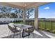 Covered patio with sleek outdoor dining set and view of fenced yard at 1593 Evening Summit Cir, Minneola, FL 34715