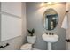 Cozy powder room with pedestal sink, an oval mirror, and modern fixtures at 1593 Evening Summit Cir, Minneola, FL 34715